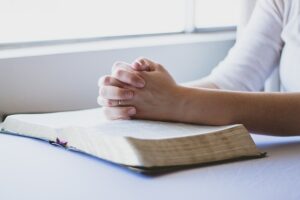 Woman pausing for prayer during her daily routine, symbolizing deepening her prayer life and connection with God